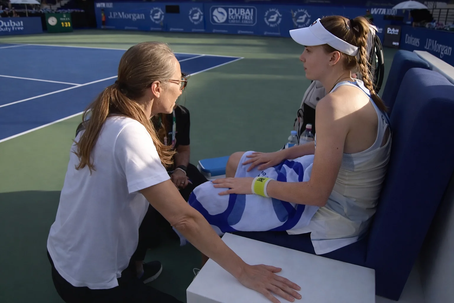 Elena Rybakina sitting courtside with her physio during the Dubai Duty Free Tennis Championships 2026 before retiring due to illness.
