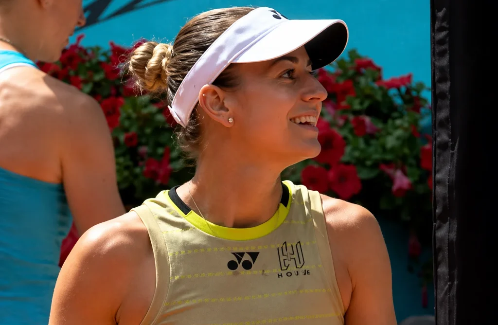 Anna Bondar smiling after a victory during a professional tennis match under sunny conditions
