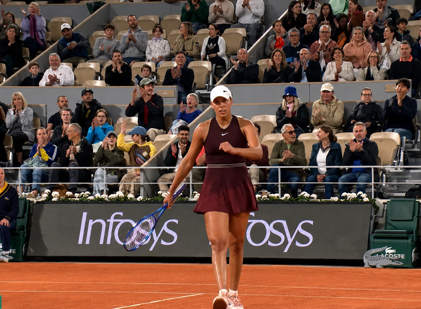 Madison Keys celebrates on a clay court at the French Open as the crowd applauds during a professional tennis match.