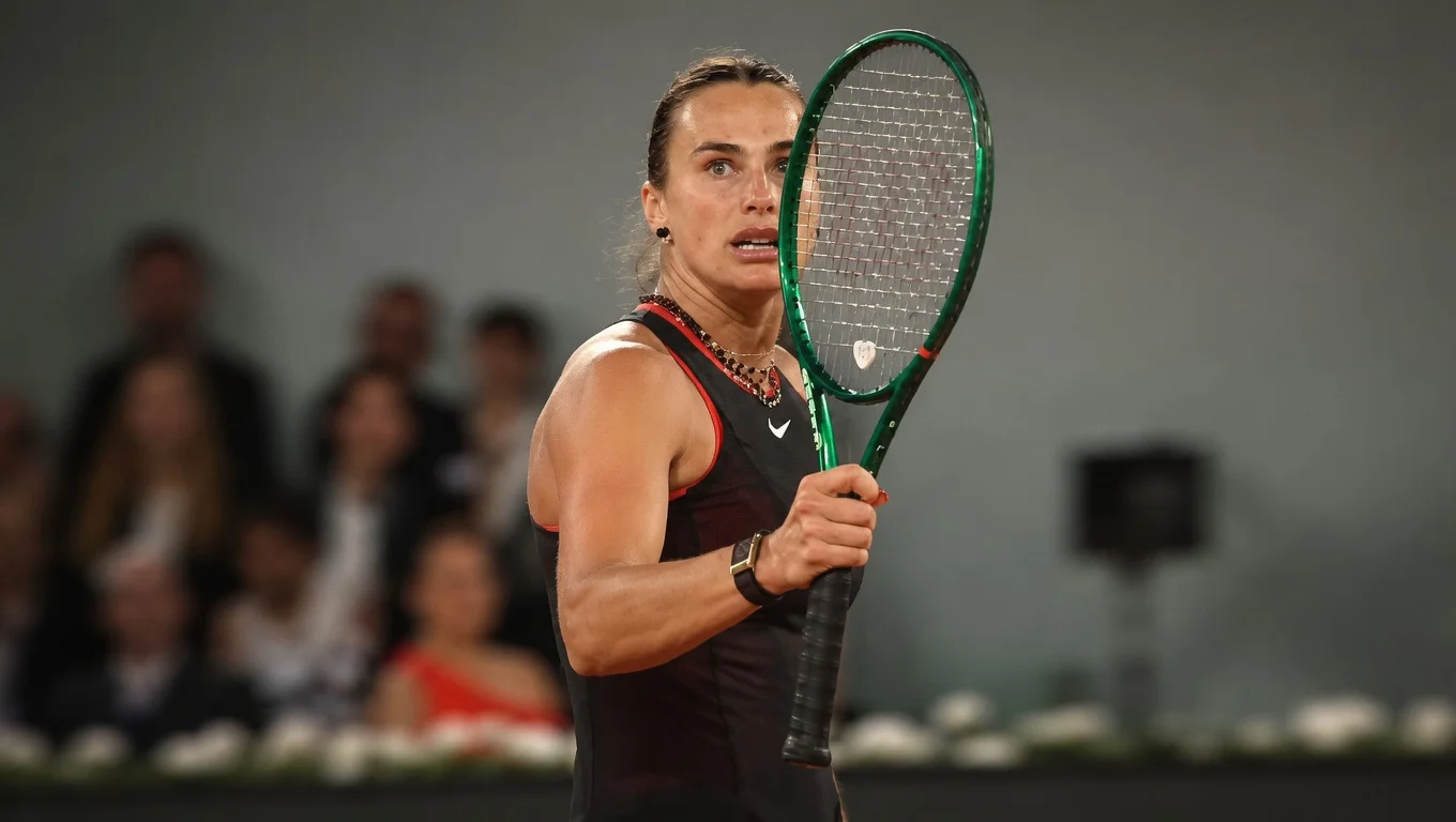 Aryna Sabalenka holds her racket during a tennis match vs. Naomi Osaka, focused on the next point in the French Open