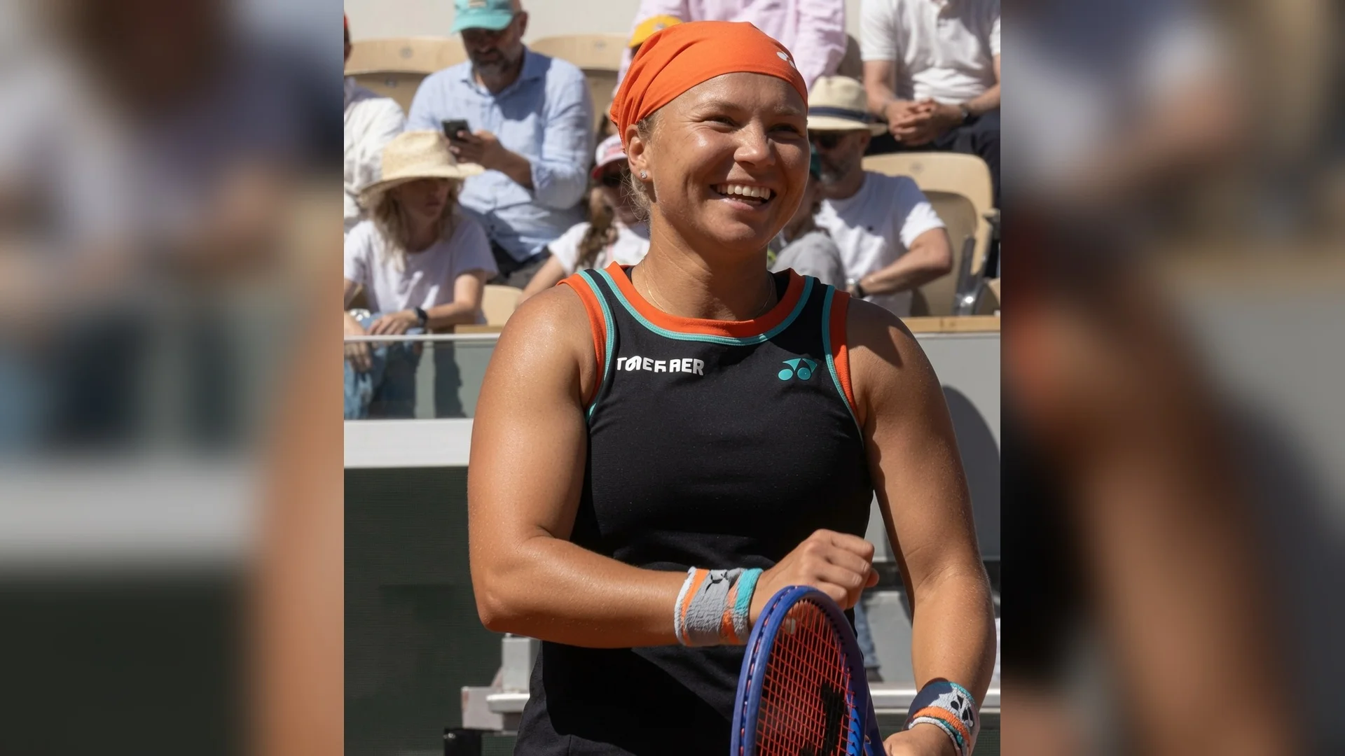 Diana Shnaider smiling on court at Roland Garros 2026 during the French Open tennis tournament after defeating Madison Keys