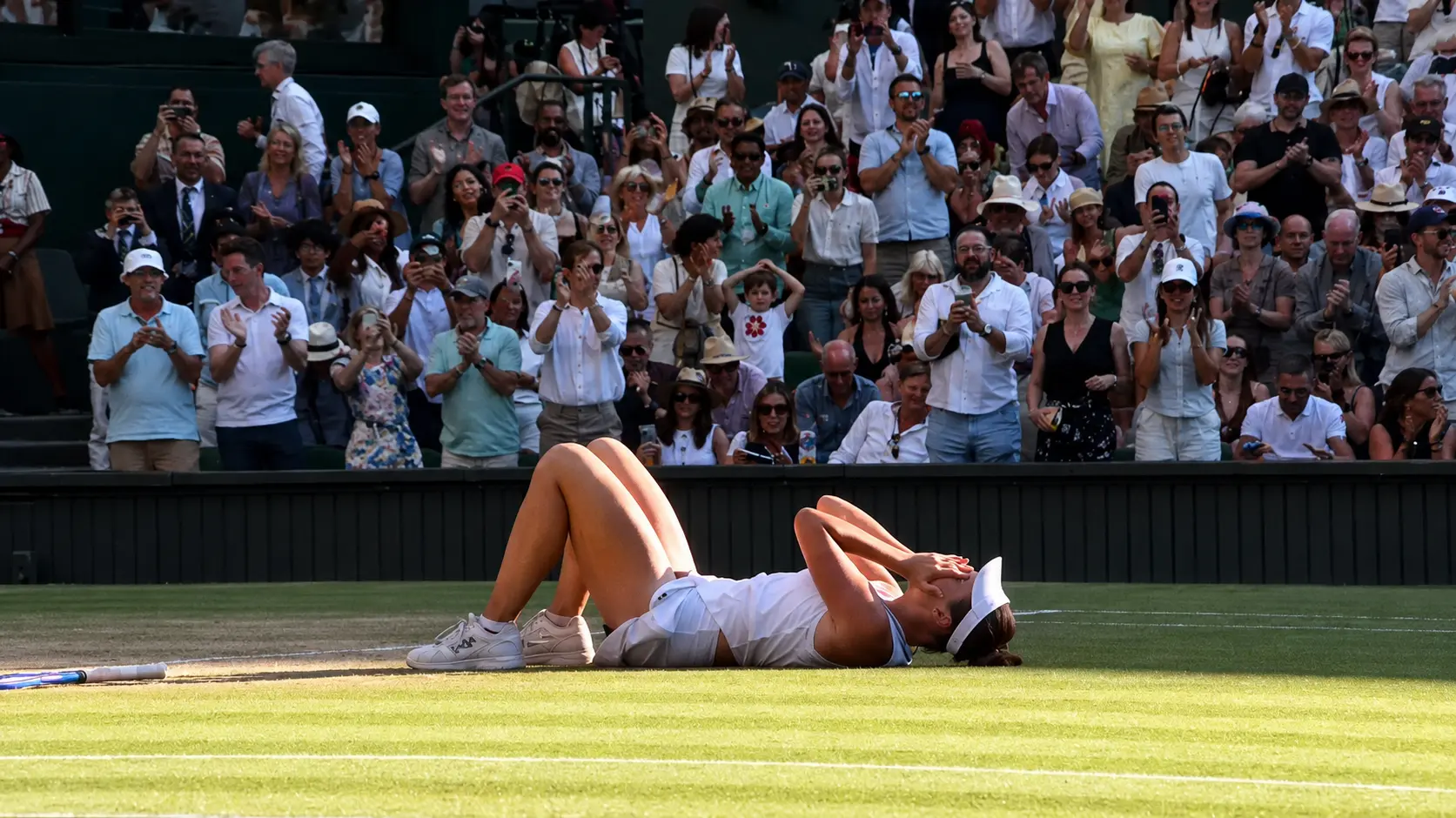 Linda Noskova lies on the Wimbledon grass after winning the 2026 Ladies’ Singles title
