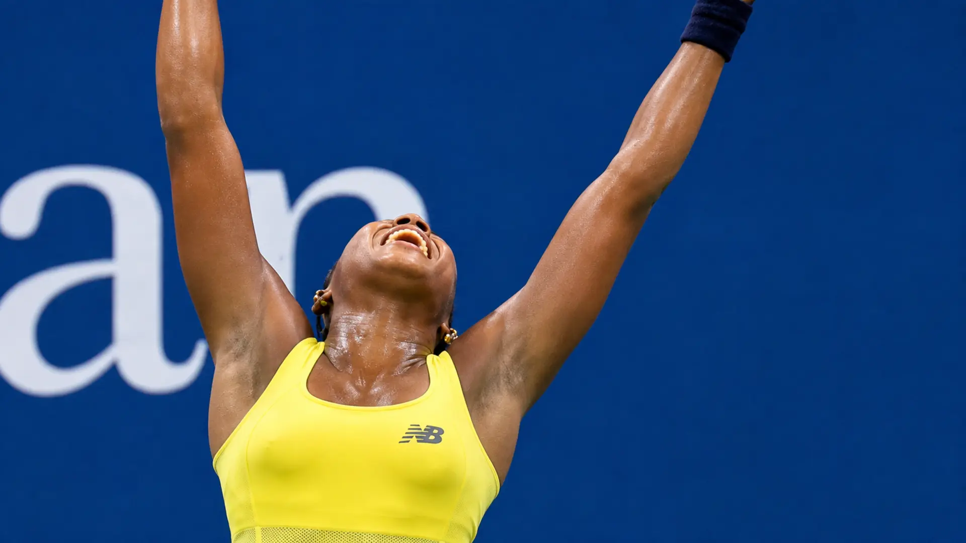 Coco Gauff raises her arms in relief after battling into the third round of the 2026 US Open