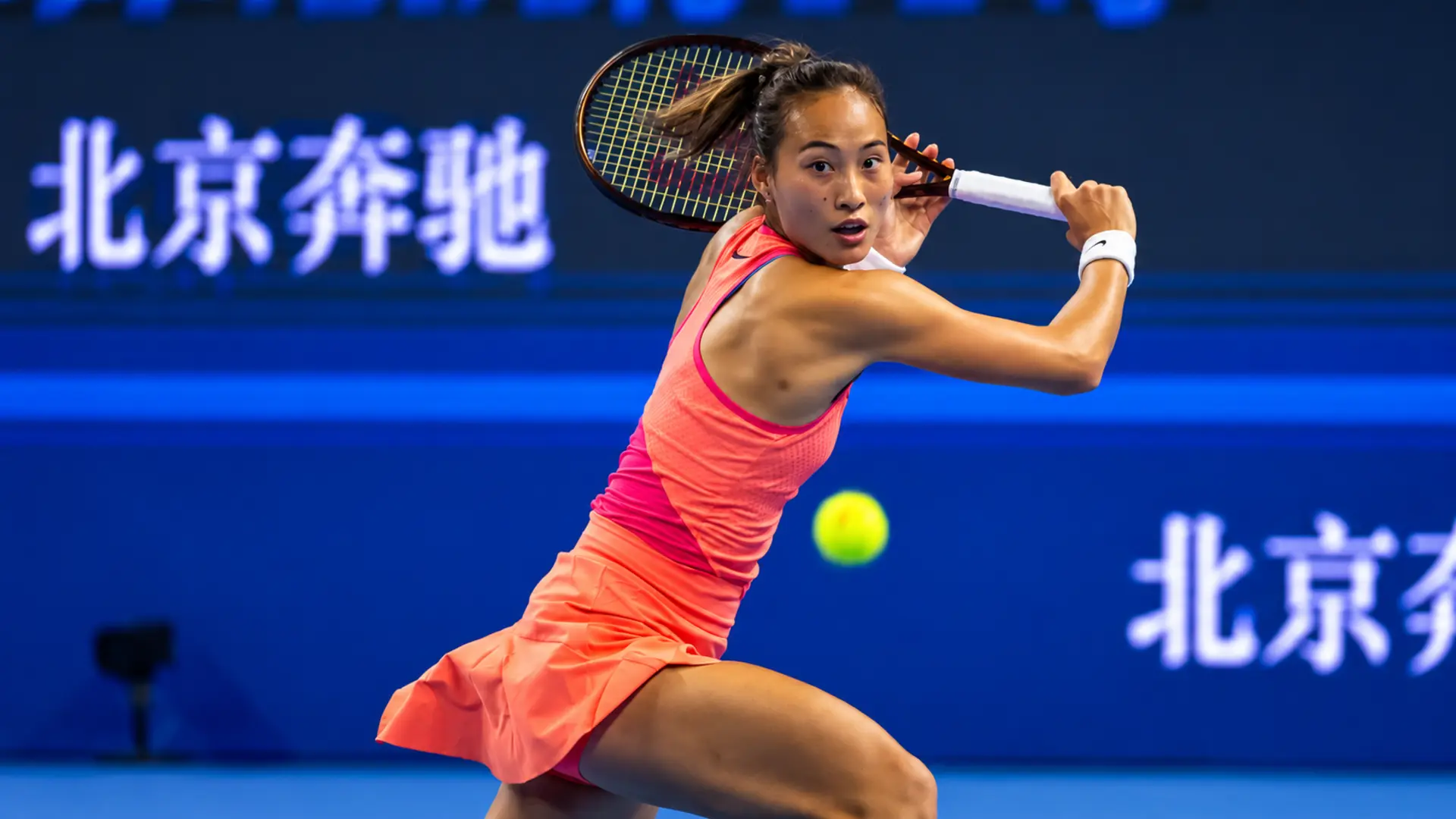 Qinwen Zheng prepares to hit a backhand during a hard-court match, featured for the China Open 2026 WTA results, draw and schedule.